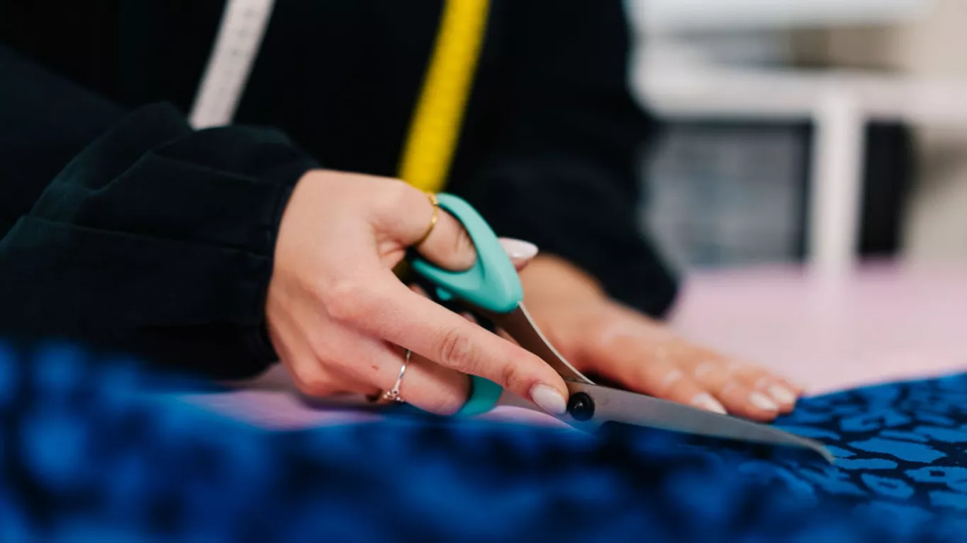 Lybstes Schnittmuster Atelier - Stoff wird zugeschnitten und im Hintergrund genäht